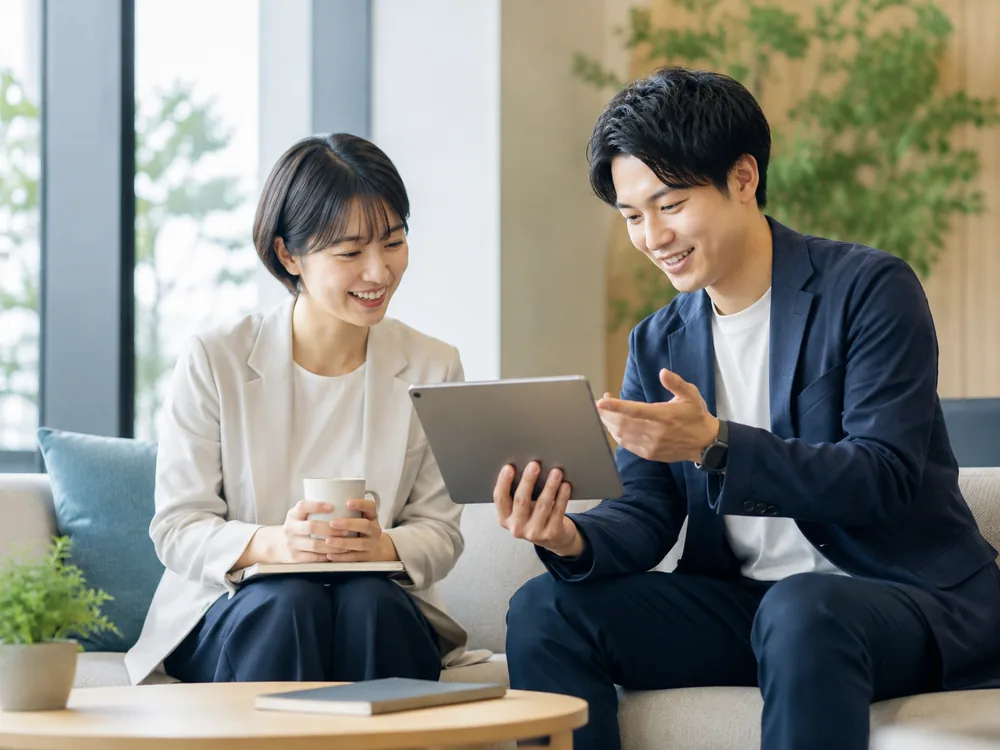 タブレットを見ながら運用状況を確認するFDEと担当者